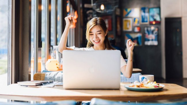 What-Is-Modern-Workplace-Experience-(1) Happy young woman in from of a laptop