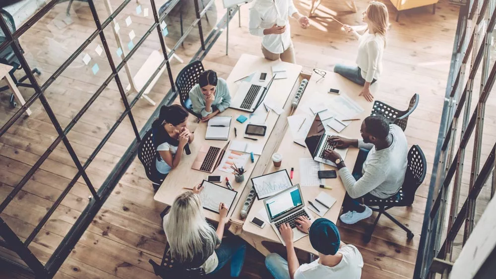 A team working at one, large table, view from top.