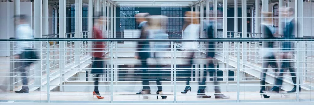 People walking in office building - blurred by movement.